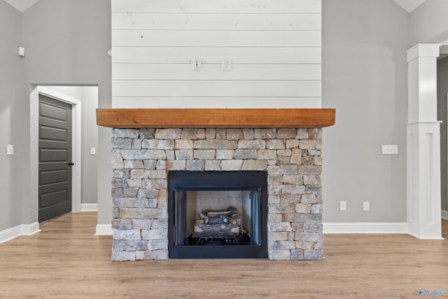 detailed view of wood finished floors, baseboards, and a fireplace