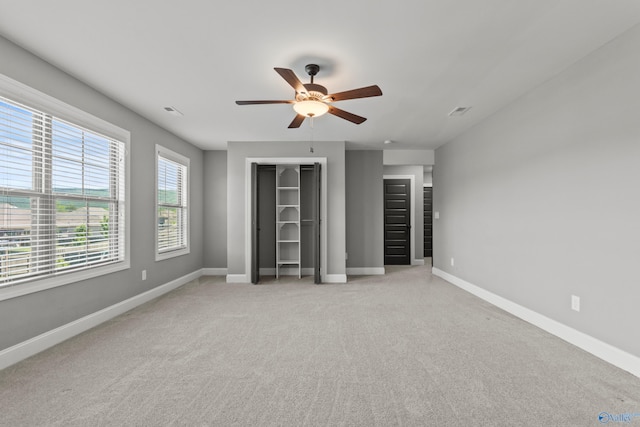 unfurnished bedroom with baseboards, light carpet, and a ceiling fan