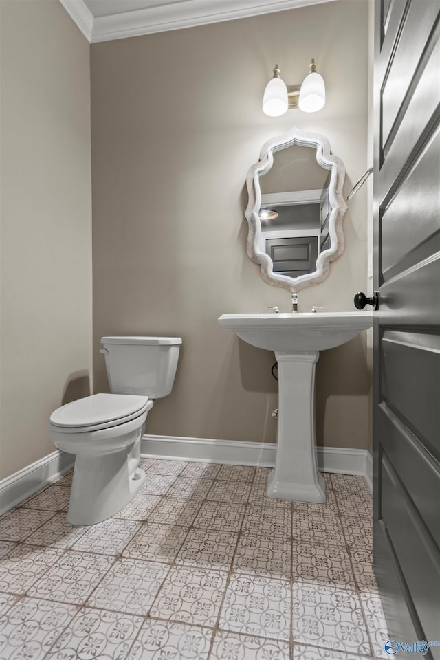 bathroom featuring crown molding, baseboards, and toilet