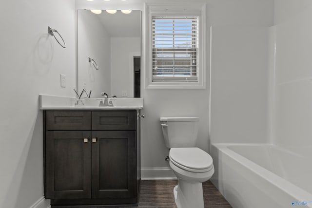 bathroom with baseboards, toilet, vanity, and wood finished floors