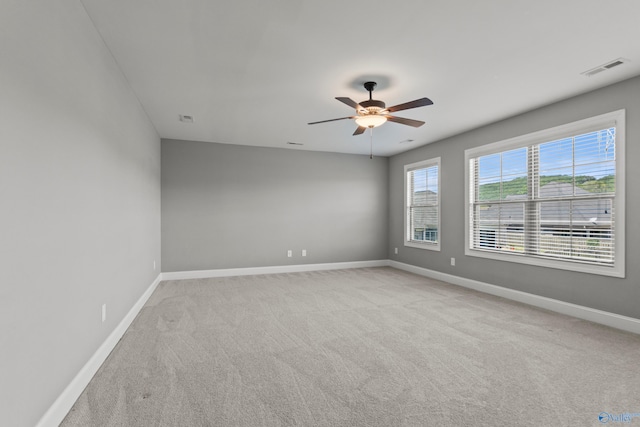 empty room featuring light carpet, baseboards, and ceiling fan