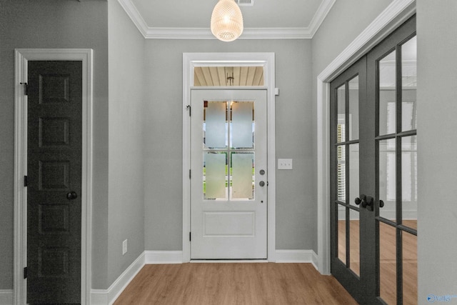 doorway to outside with french doors, wood finished floors, crown molding, and baseboards
