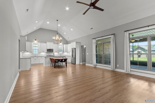 living area with a chandelier, high vaulted ceiling, a ceiling fan, light wood-style flooring, and recessed lighting