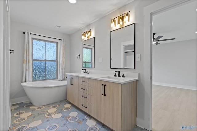 full bathroom featuring a ceiling fan, a sink, a soaking tub, double vanity, and visible vents