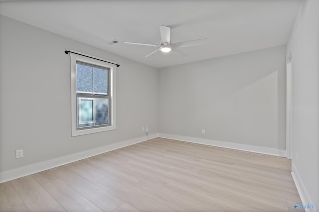 unfurnished room with light wood-type flooring, baseboards, a ceiling fan, and visible vents