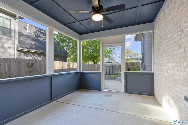 unfurnished sunroom with ceiling fan