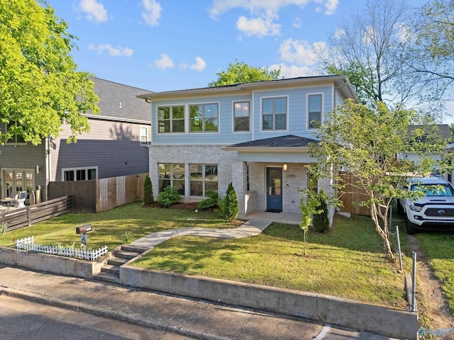 view of front of house with brick siding, fence, and a front yard