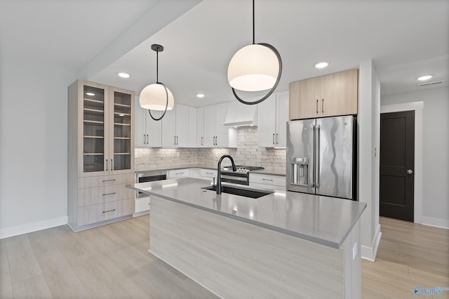 kitchen with stainless steel fridge with ice dispenser, backsplash, a sink, premium range hood, and baseboards