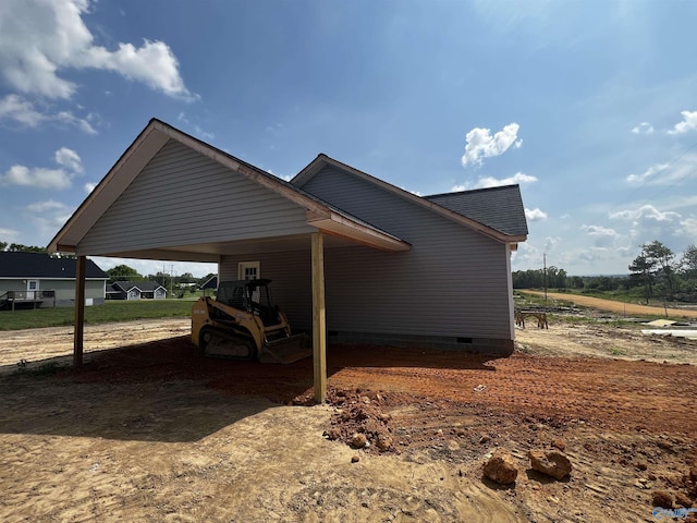 view of side of home with an attached carport and crawl space