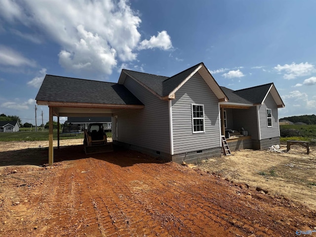 view of side of property with roof with shingles and crawl space