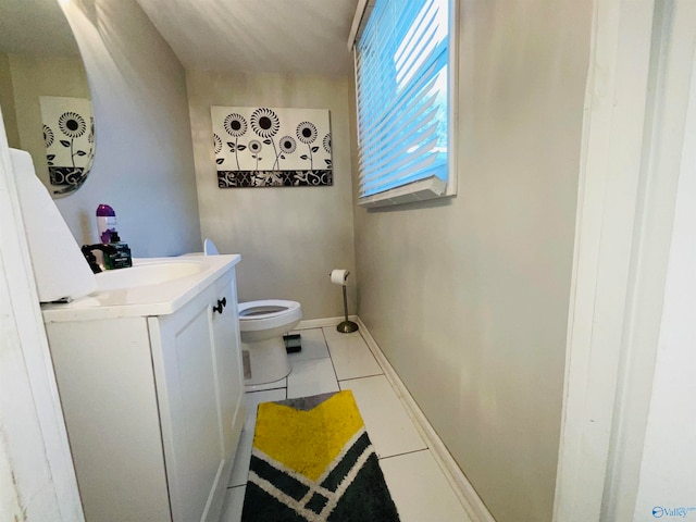 bathroom with toilet, vanity, and tile patterned flooring