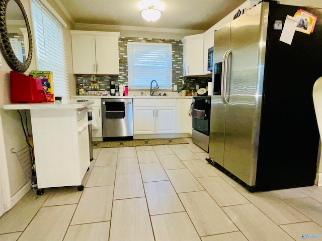 kitchen with white cabinetry, stainless steel appliances, sink, and backsplash