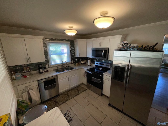 kitchen featuring tasteful backsplash, sink, stainless steel appliances, white cabinets, and ornamental molding