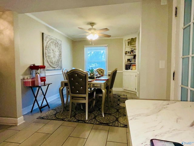 dining room with crown molding, light hardwood / wood-style flooring, built in shelves, and ceiling fan