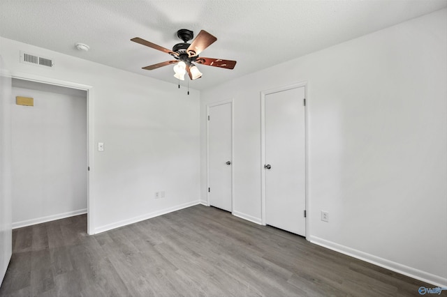 unfurnished bedroom featuring visible vents, baseboards, and wood finished floors