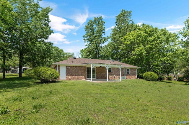 back of property with brick siding, a patio area, and a yard