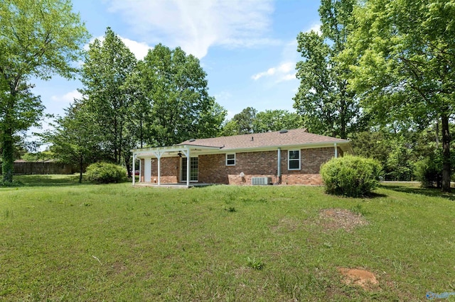 rear view of property with cooling unit, a yard, a patio area, and brick siding