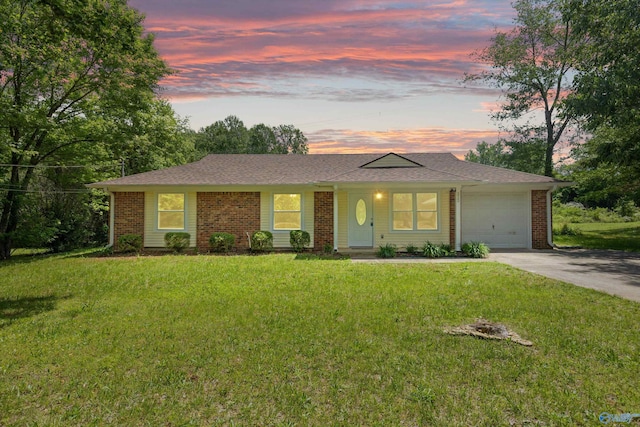 ranch-style house with a garage, a lawn, concrete driveway, and brick siding