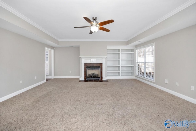 unfurnished living room with carpet flooring, a tile fireplace, baseboards, and ceiling fan