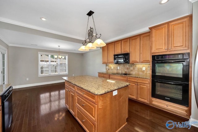 kitchen with baseboards, decorative backsplash, black appliances, a notable chandelier, and a center island