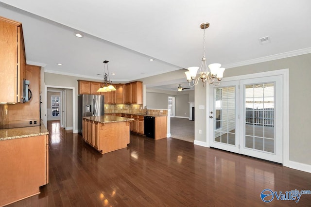 kitchen with tasteful backsplash, visible vents, a kitchen island, appliances with stainless steel finishes, and a notable chandelier