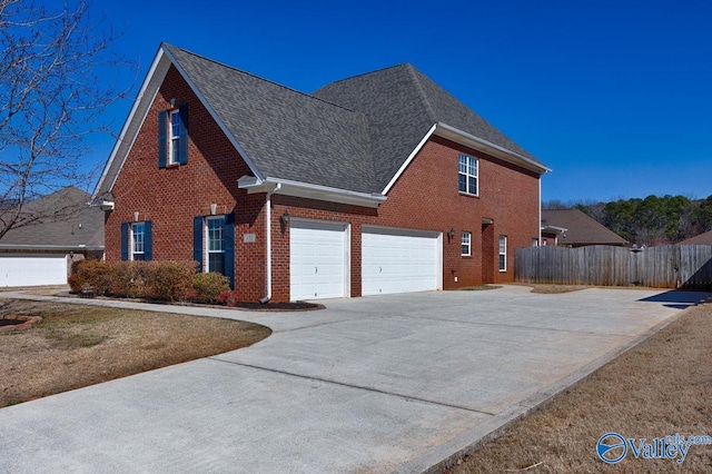 view of side of property with driveway, fence, a shingled roof, a garage, and brick siding