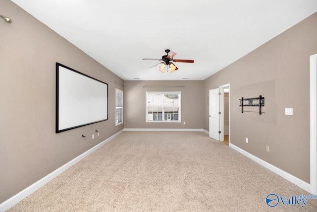 cinema with baseboards, light carpet, and a ceiling fan