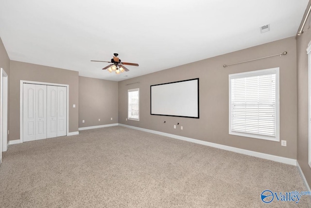 home theater room featuring carpet flooring, baseboards, visible vents, and ceiling fan