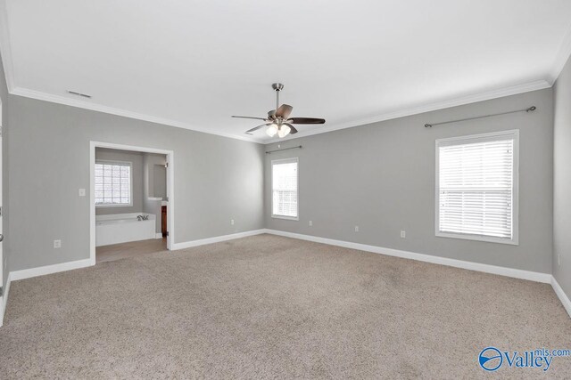 empty room with a ceiling fan, visible vents, carpet, baseboards, and ornamental molding