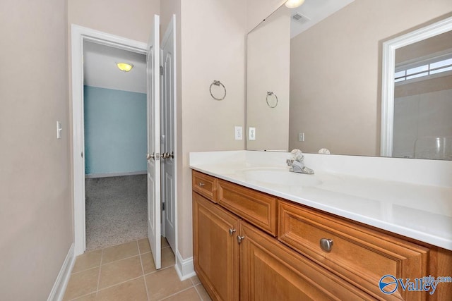 bathroom featuring tile patterned flooring, vanity, visible vents, and baseboards