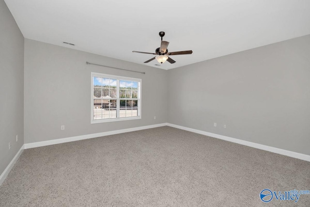 carpeted empty room with visible vents, baseboards, and ceiling fan