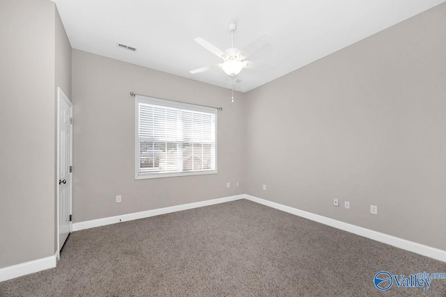 carpeted spare room with visible vents, baseboards, and ceiling fan