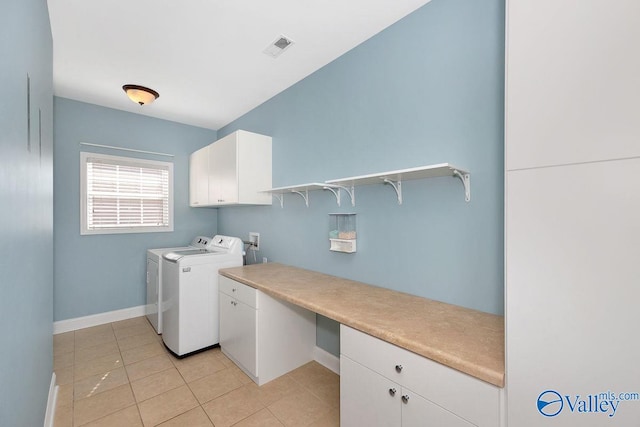 washroom featuring visible vents, washing machine and dryer, cabinet space, light tile patterned floors, and baseboards