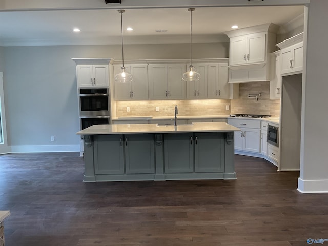 kitchen with a kitchen island with sink, stainless steel appliances, and white cabinets