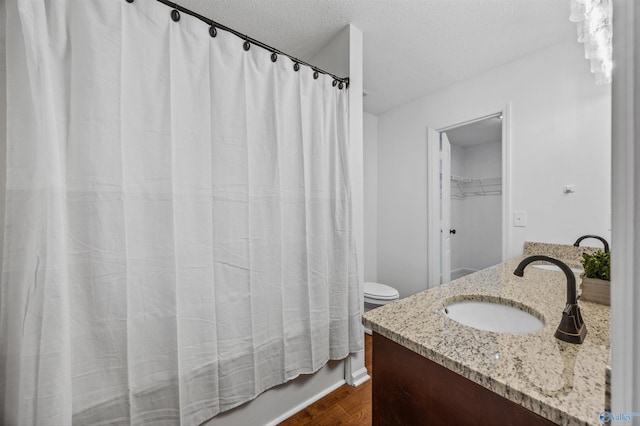 138 Spring Farm Rd, Huntsville, AL 35811 - bathroom featuring a textured ceiling, wood finished floors, vanity, and shower / tub combo