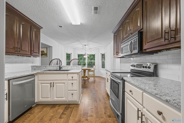 138 Spring Farm Rd, Huntsville, AL 35811 - kitchen with stainless steel appliances, a textured ceiling, dark wood-style floors, tasteful backsplash, and dark brown cabinets