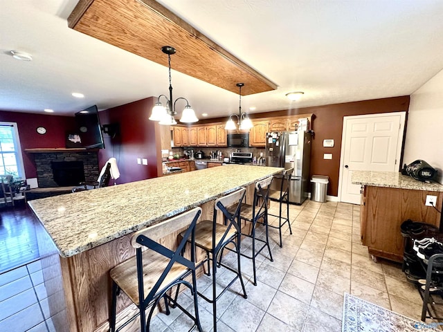 175 County Road 23, Leesburg, AL 35983 - kitchen with stainless steel appliances, a fireplace, light stone countertops, a spacious island, and a breakfast bar area