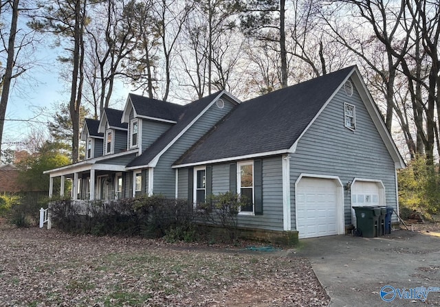 view of side of home with concrete driveway, roof with shingles, and an attached garage