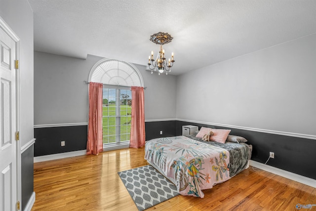 152 W Dr, Fyffe, AL 35971 - bedroom featuring a chandelier, wood finished floors, baseboards, and a textured ceiling