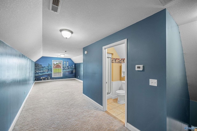 152 W Dr, Fyffe, AL 35971 - hallway with carpet flooring, vaulted ceiling, a textured ceiling, baseboards, and tile patterned floors
