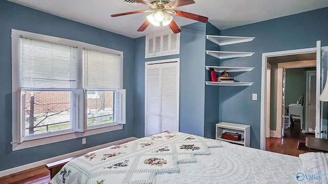 bedroom with a ceiling fan, baseboards, visible vents, and wood finished floors