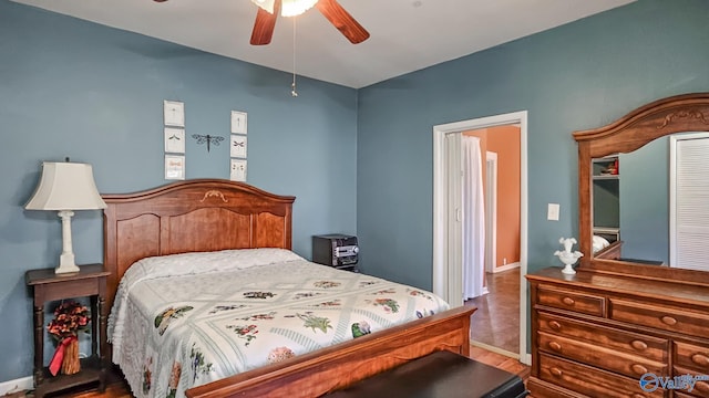 bedroom with a ceiling fan, baseboards, and wood finished floors