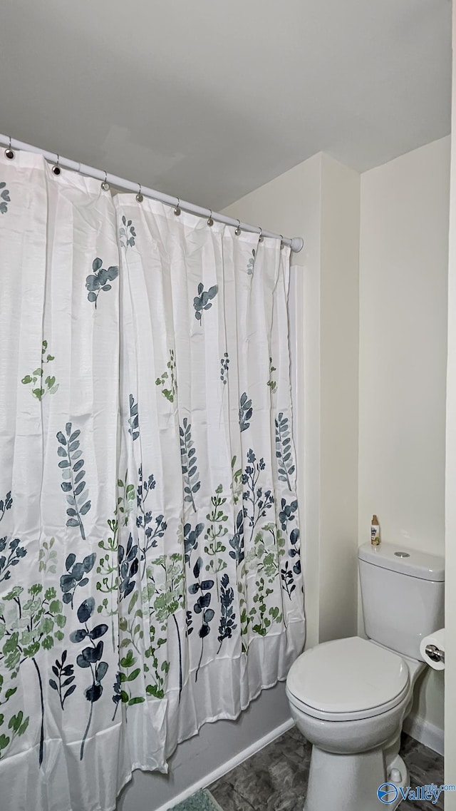 full bathroom featuring shower / bath combination with curtain and toilet