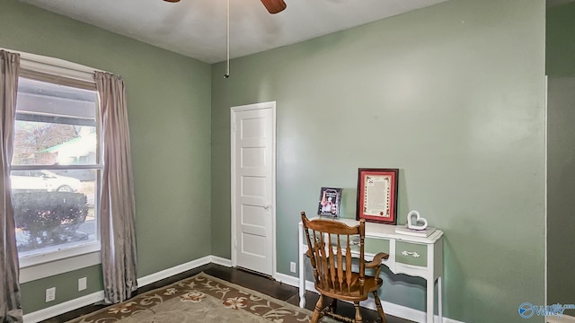 home office featuring dark wood-style flooring, ceiling fan, and baseboards