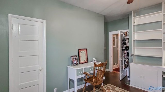 office area with dark wood-type flooring, baseboards, and a ceiling fan