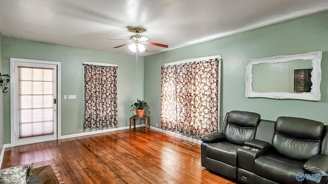 unfurnished room with hardwood / wood-style floors, a ceiling fan, and baseboards