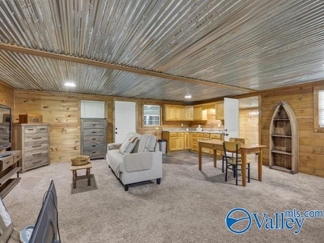 carpeted living room featuring wooden walls