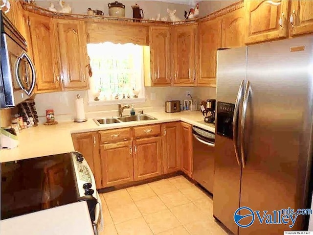 430 Timber Trl, Ashville, AL 35953 - kitchen featuring stainless steel appliances, a sink, light countertops, light tile patterned flooring, and brown cabinets