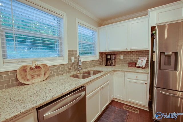 kitchen featuring sink, white cabinetry, stainless steel appliances, light stone countertops, and backsplash