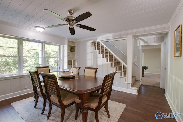 dining room with crown molding, dark hardwood / wood-style floors, and built in shelves